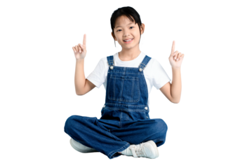 A cheerful young girl sitting with legs crossed and pointing upwards on PNG 