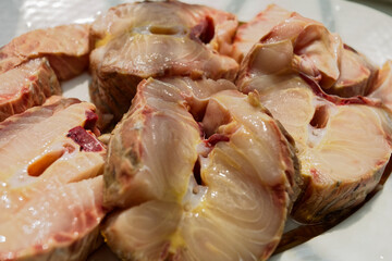 Freshly cut, thick pork shoulder steaks displayed on a white plate, showcasing natural marbling. Ideal for grilling, braising, or slow cooking, these steaks are glistening with fresh juices and a mix