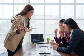 Businesswoman scolding employees during office meeting about bad results