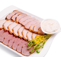 Gourmet platter featuring sliced meats with garnishes and dipping sauce