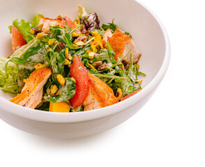 Fresh salad with grilled chicken, mixed greens, and nuts on a white background