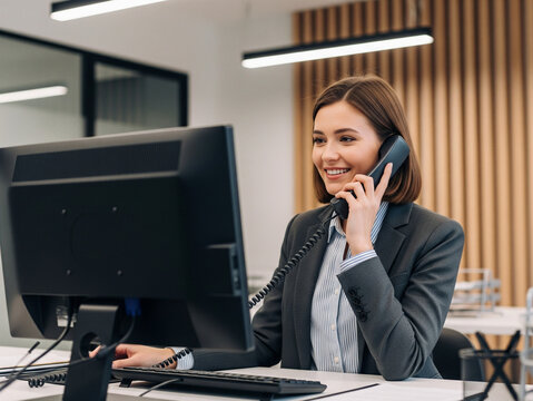 Friendly receptionist answering phone calls with a warm smile.