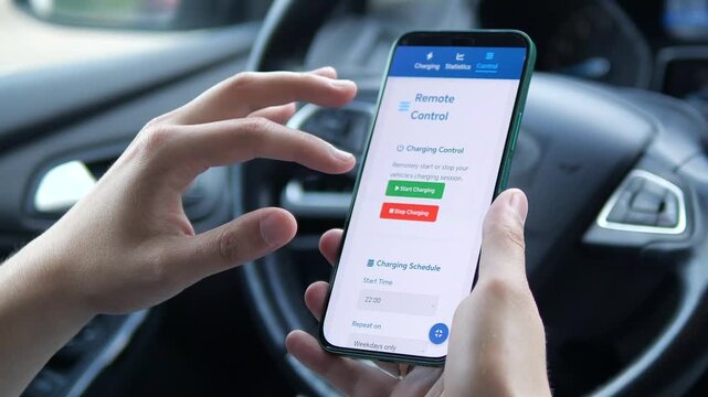 Close-up of a driver's hands in a car using a dedicated mobile application to manage an electric vehicle charging session. He navigates the interface, reviews real-time charging data, and initiates