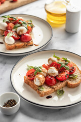 Caprese sandwich or toast with mozzarrella balls, cherry tomatoes, olive oil, pepper and fresh basil leaves. Healthy vegetarian breakfast, snack or lunch. White marble background