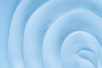 Close-up of a creamy cosmetic gel texture featuring smooth, flowing circles. The soft blue color and minimalist aesthetic create a soothing, elegant visual.