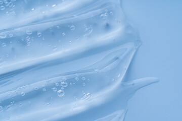 blue makeup gel swatches with a glossy sheen, photographed on a matching neutral background