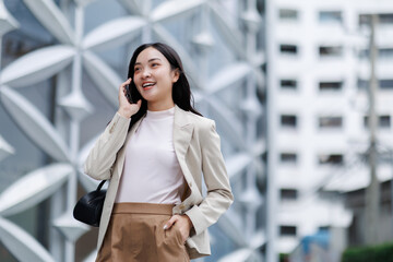 Fototapeta premium Businesswoman talking on phone in city center