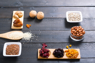 sun dried super foods, nuts and seeds, frame on black wood table background
