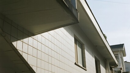Modern Building Facade with White Tiles and Overhanging Roof