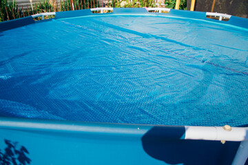 The blue coating of the pool, reflecting sunlight, emphasizes summer recreation and pool...