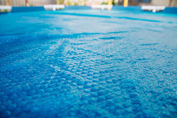The blue coating of the pool, reflecting sunlight, emphasizes summer recreation and pool...