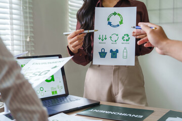 Businesswoman explaining recycling and esg to colleagues in meeting