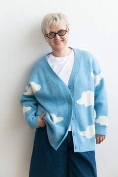 Non binary person smiling in casual blue outfit