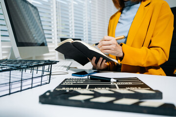 Businesswoman in yellow blazer planning strategy with charts and reports, perfect for corporate,...