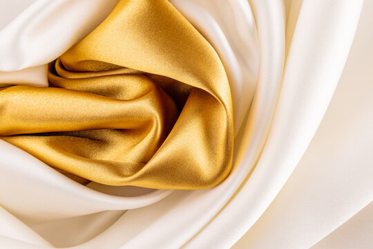Satin fabric with white and golden folds