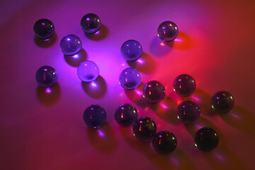 Scientific experiment with glass marbles showing light refraction, colorful spectrum and optical physics effects in dark background setting
