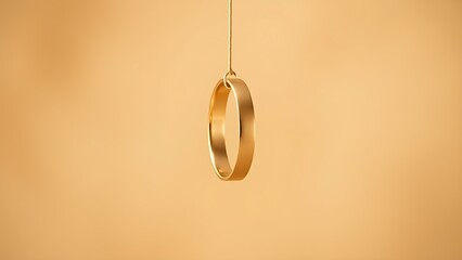 Three golden wedding bands suspended vertically against a soft beige backdrop.