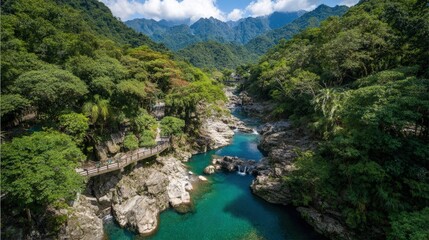 Aerial View Of Turquoise River Winding Through Lush Green Mountains
