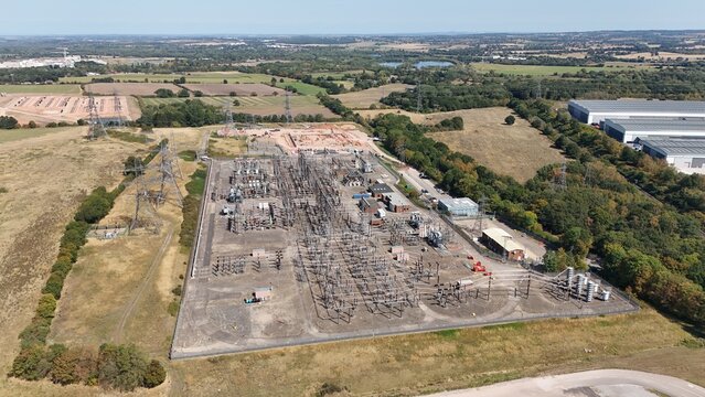 Aerial drone shot of electrical sub station with powerlines, transformers and pylons in England UK near Birmingham 