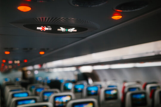 Airplane cabin interior with passenger seats and signs