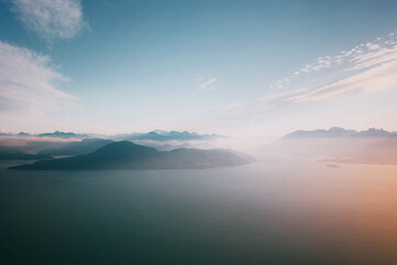 Serene aerial view over misty mountains and calm sea