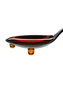 Ultra-macro, stainless steel tablespoon holding viscous amber asian fish sauce with high meniscus & suspended droplet, isolated on transparent background, concept of liquid dynamics & anticipation