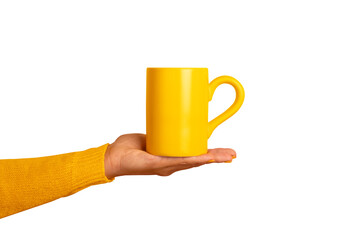 A person's hand in a yellow sleeve holds a bright yellow ceramic mug on transparent background,...
