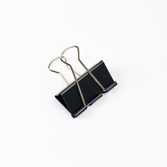 Black binder clip on a white background