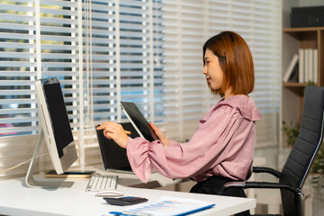 Business concepts, women working in the work area with tablet and data sheets at the desk.