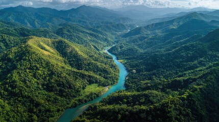 Aerial View of Lush Green Mountains and Serpentine River Flowing Through Rolling Hills Under a Dramatic Sky with Clouds and Sunlight in the Background