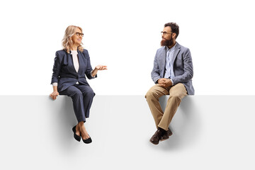 Work colleagues sitting on a blank panel and having a conversation
