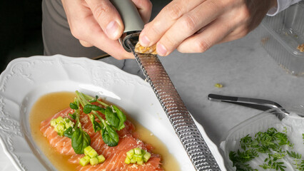 Salmon carpaccio artistry, hands grating mystery indulgence, gourmet yin-yang, tinged with vernal freshness, Mother's Day brunch vibes