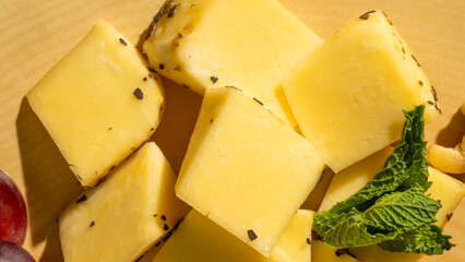 Cheerful cheddar cubes adorned with mint leaves, perfect for Fromage Friday celebration and lactose festivity, tantalizing culinary delight
