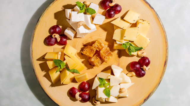 Creamy cheese medley with succulent grapes and vibrant honeycomb, perfect for Fromage Fridays or National Cheese Lover's Day
