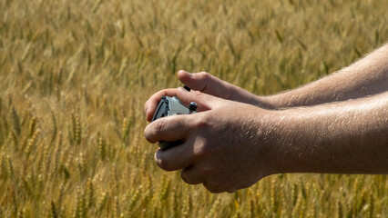 In sunlit wheat fields, a device cradled by fair-skinned hands unlocks drone-aided harvest myths, echoing Lammas lore