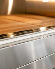 Illuminated by golden light, a sleek industrial oven awaits autumnal bread rituals, evoking...