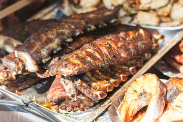 Ribs are on a tray with other meats and vegetables