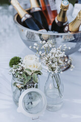 Champagne bottles on ice with floral jars at elegant wedding cocktail