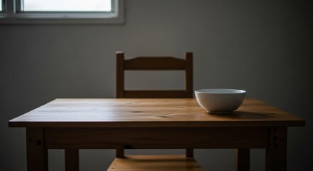 Simple Wooden Table with Chair and Bowl in Dimly Lit Room.