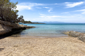 Tranquil sandy beach. with turquoise sea in Porto Cheli Greece on a bright summer day