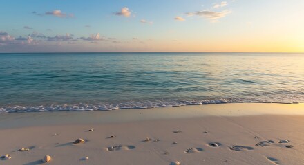 Calm turquoise ocean waves gently lapping onto white sandy beach at sunset, creating a peaceful and serene coastal scene, perfect for relaxation.