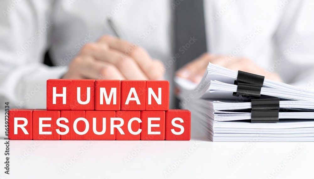Poster close-up view of the text human resources composed of red blocks, with a blurred background of docum