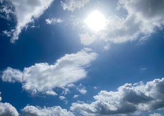 Bright Sun and Fluffy Clouds in a Blue Sky