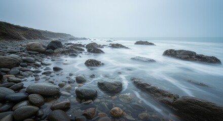 Obraz premium Serene Coastal Landscape with Fog and Smooth Ocean Waves