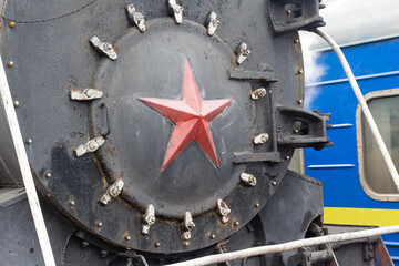 Big red star on front of an black historic locomotive. Old Russian locomotive