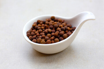 Brown dried allspice spice seeds.