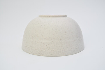 Minimalist ceramic bowl upside down on white background, simple design with speckled texture for...