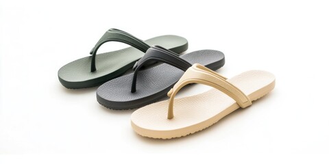 Three pairs of simple flip-flops are arranged on a white surface. The flip-flops come in black, dark green, and beige colors. 