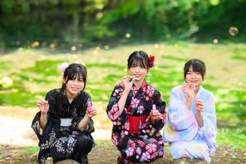 浴衣を着た日本人の小学生の女の子がシャボン玉で遊ぶ夏の風景