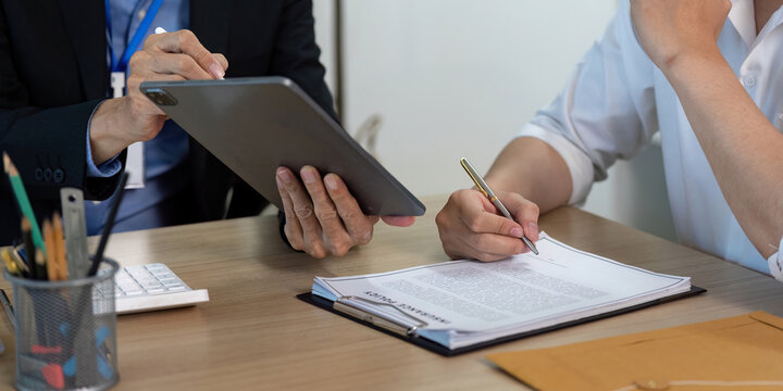 Insurance Business. Professional discussing policy details on tablet with client. - Powered by Adobe